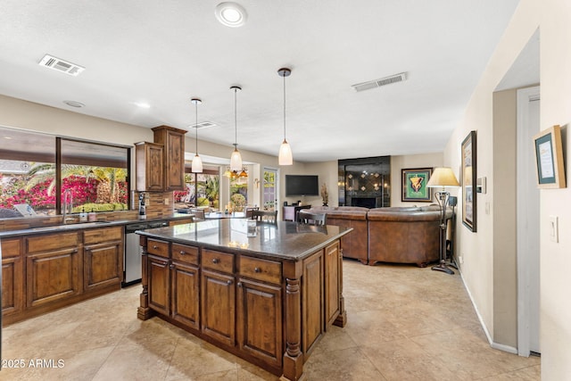 kitchen featuring a sink, a kitchen island, visible vents, and stainless steel dishwasher