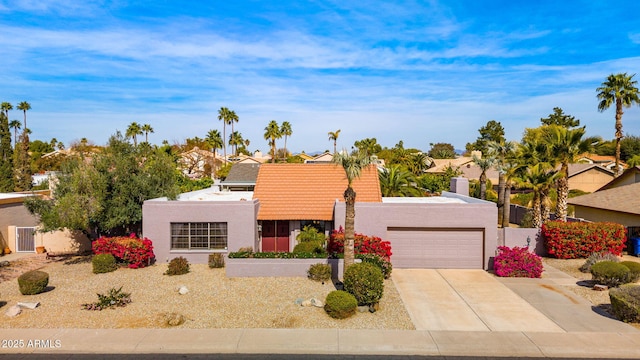 view of front of home featuring an attached garage, concrete driveway, and stucco siding