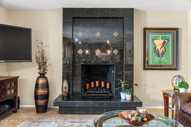 tiled living area featuring a tiled fireplace and baseboards