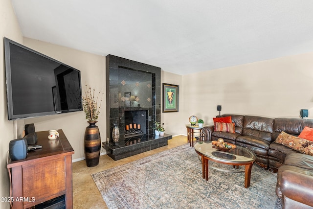 living area featuring a tile fireplace and baseboards