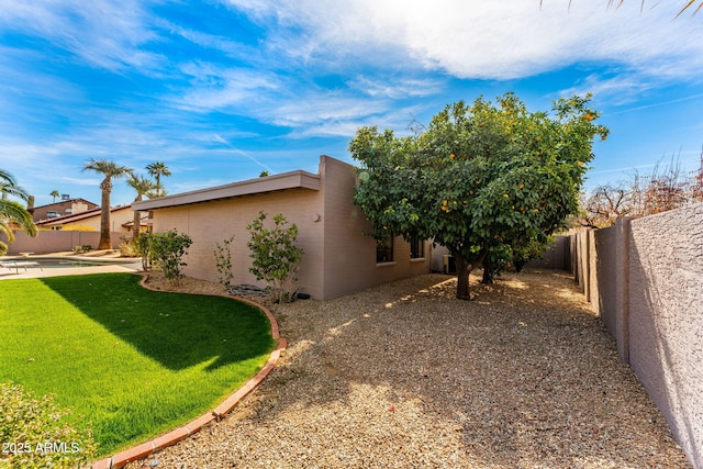 view of home's exterior featuring a patio area, a fenced backyard, and a yard