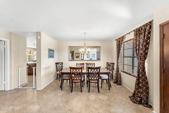 dining space with baseboards and a notable chandelier