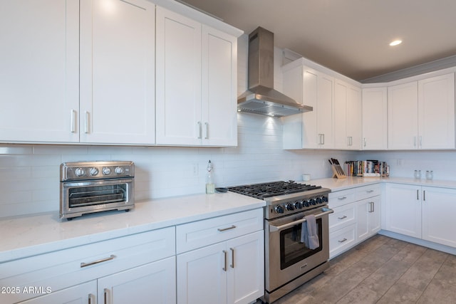 3834 E Clarendon Ave, Phoenix, AZ 85018 - kitchen with wall chimney exhaust hood, stainless steel stove, white cabinetry, decorative backsplash, and light stone countertops