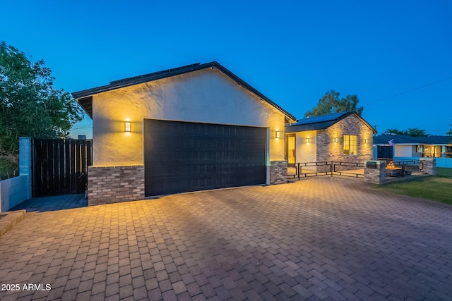 3834 E Clarendon Ave, Phoenix, AZ 85018 - modern home with an attached garage, stucco siding, a gate, driveway, and solar panels