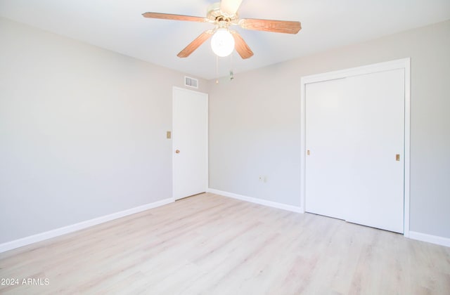 unfurnished bedroom featuring ceiling fan, a closet, and light hardwood / wood-style flooring