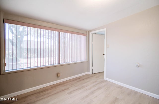 empty room featuring light hardwood / wood-style floors and vaulted ceiling