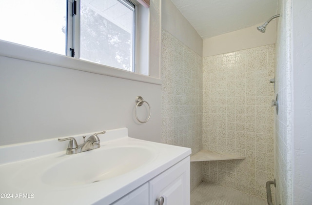 bathroom featuring vanity and tiled shower