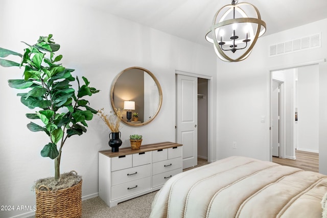 18348 W Gray Fox Trl, Wittmann, AZ 85361 - bedroom with baseboards, light colored carpet, a notable chandelier, and visible vents