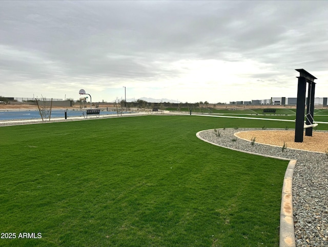 view of home's community featuring community basketball court and a yard