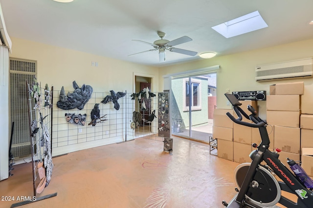 exercise room with ceiling fan, a skylight, concrete floors, and a wall unit AC