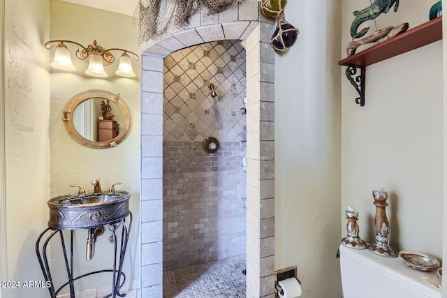 bathroom with tiled shower and toilet