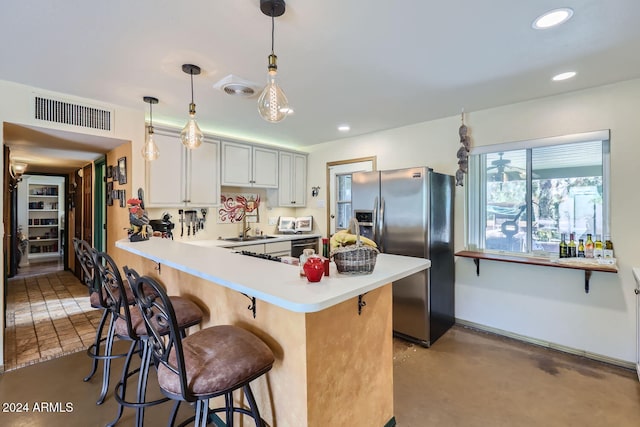 kitchen featuring white cabinets, hanging light fixtures, sink, a kitchen breakfast bar, and stainless steel appliances