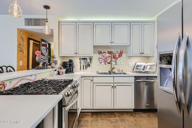 kitchen with decorative light fixtures, stainless steel appliances, sink, and white cabinetry