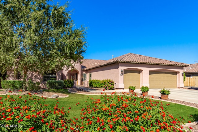 mediterranean / spanish-style house with a front yard and a garage