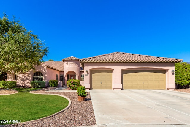 mediterranean / spanish-style house with a front yard and a garage