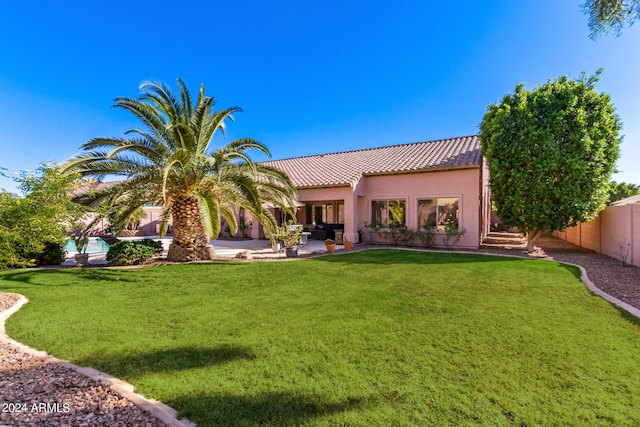 back of house with a patio area and a lawn