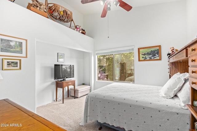 bedroom featuring carpet floors, a high ceiling, and ceiling fan