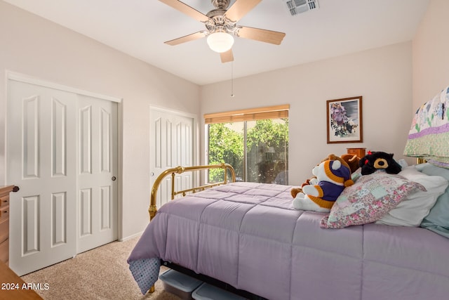 bedroom featuring two closets, carpet, and ceiling fan