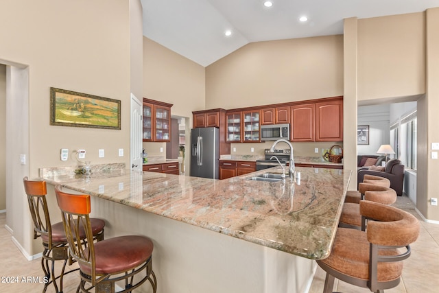 kitchen featuring light tile patterned flooring, sink, kitchen peninsula, high vaulted ceiling, and stainless steel appliances