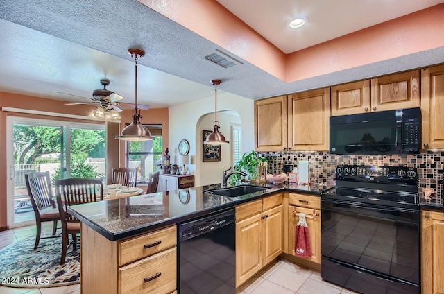 kitchen with visible vents, a peninsula, a sink, black appliances, and backsplash