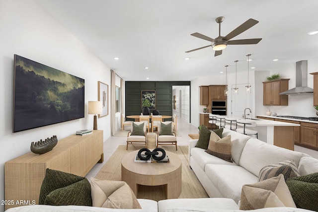 living room with sink, light tile patterned floors, and ceiling fan