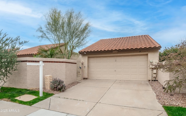 view of front of property featuring stucco siding, a tile roof, and a garage