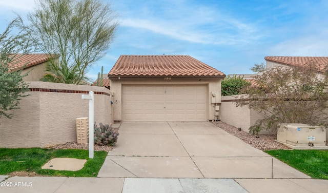 garage featuring concrete driveway and fence