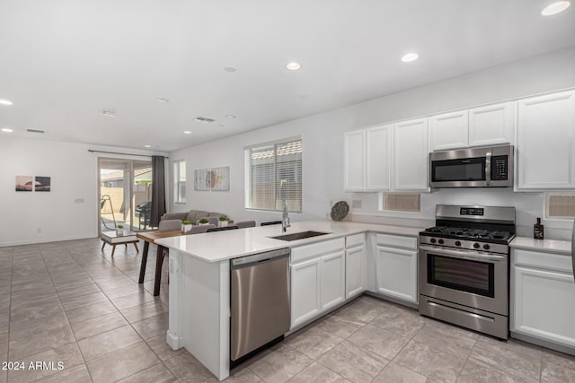 kitchen featuring kitchen peninsula, appliances with stainless steel finishes, and white cabinets