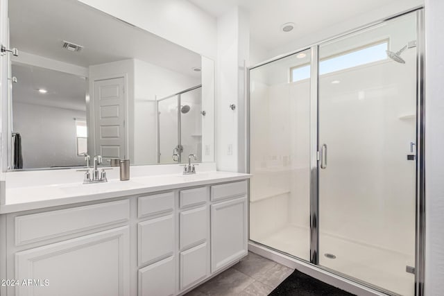 bathroom with tile patterned floors, vanity, and walk in shower