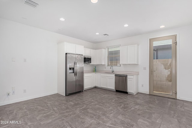 kitchen with white cabinets, appliances with stainless steel finishes, and sink