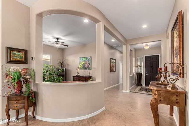 corridor with baseboards, arched walkways, and recessed lighting