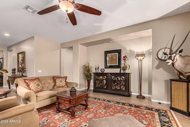 living area with light tile patterned floors, baseboards, visible vents, and a ceiling fan