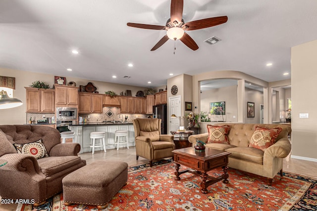 living room featuring a ceiling fan, recessed lighting, visible vents, and arched walkways