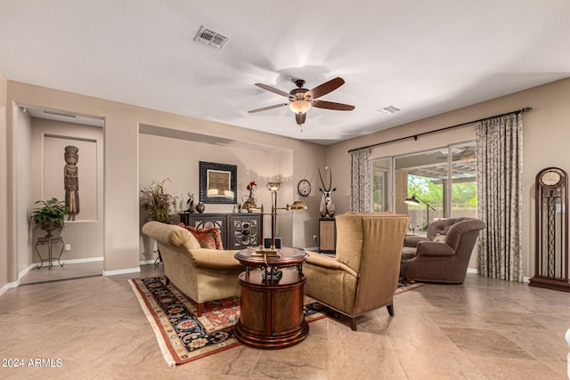 living area featuring baseboards, visible vents, and a ceiling fan