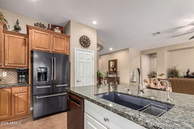 kitchen featuring tasteful backsplash, visible vents, dishwashing machine, high quality fridge, and a sink