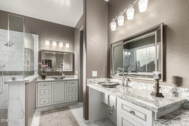 bathroom with a textured wall, marble finish floor, a stall shower, and vanity