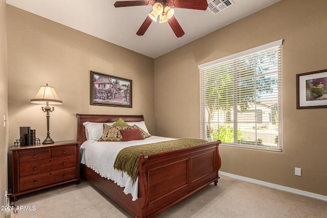 bedroom featuring a ceiling fan, light colored carpet, visible vents, and baseboards