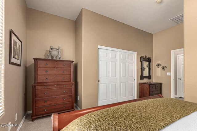 bedroom featuring a closet, carpet, visible vents, and baseboards