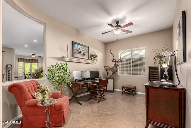 office space featuring a ceiling fan and baseboards