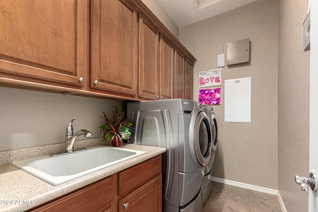 washroom with light tile patterned floors, cabinet space, a sink, separate washer and dryer, and baseboards