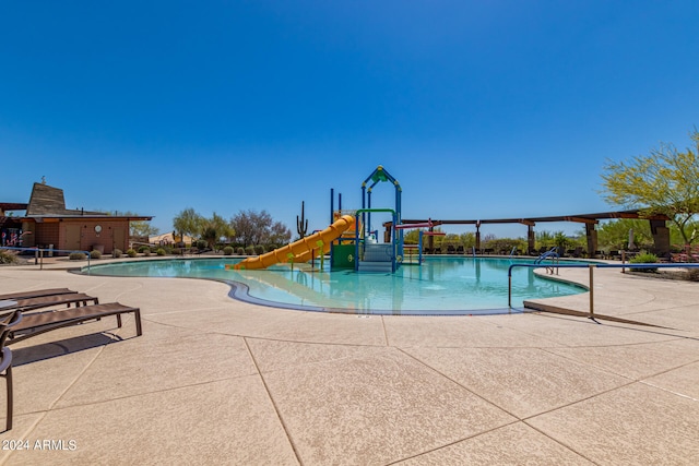 view of pool with playground community, a water play area, and a water slide