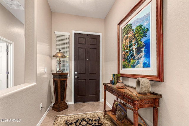 foyer featuring baseboards, visible vents, and light tile patterned flooring