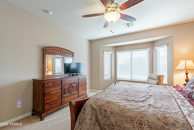 bedroom featuring baseboards, ceiling fan, visible vents, and light colored carpet