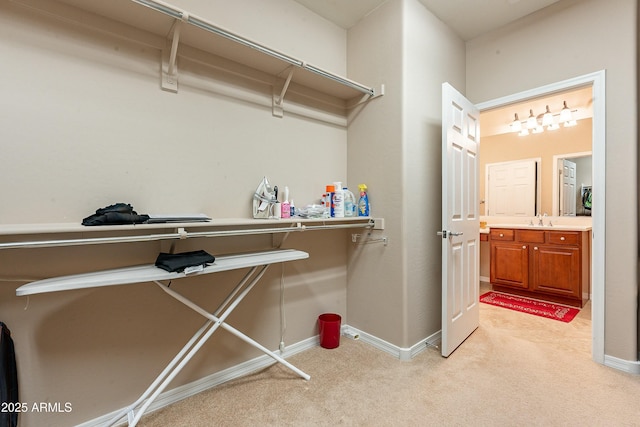 spacious closet with light carpet and a sink