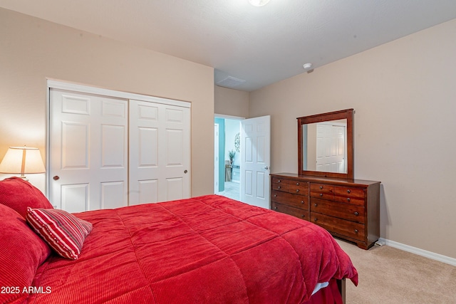 bedroom featuring a closet, light carpet, and baseboards