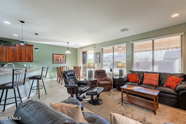 living room with baseboards, visible vents, and recessed lighting