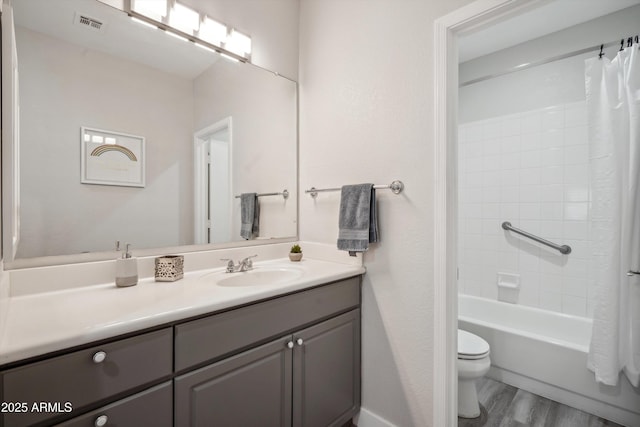 full bathroom with wood finished floors, toilet, vanity, and shower / tub combo