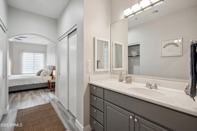 ensuite bathroom with wood finished floors and vanity