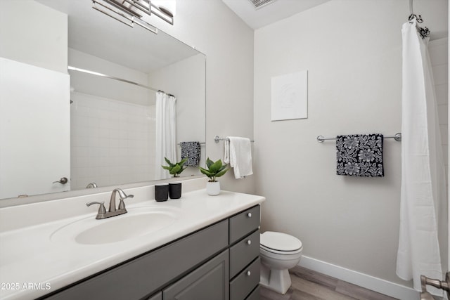 bathroom with wood finished floors, toilet, baseboards, vanity, and curtained shower