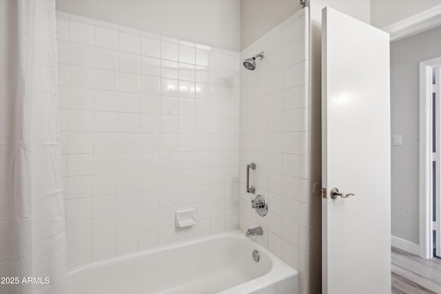 bathroom with shower / bathtub combination with curtain and wood finished floors